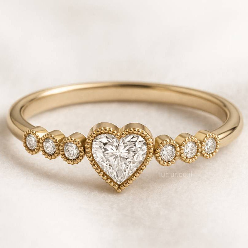 Gold ring with a heart-shaped diamond on a light background
