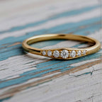 Gold ring with diamonds on a wood background