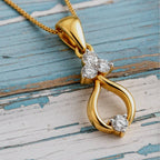  gold pendant with diamonds on a soft wood background