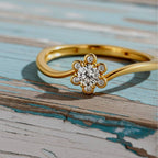 Gold ring with a diamond on a wood background