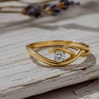Gold ring with a diamond on Wood background