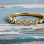 Gold ring with diamond accents on a wood background