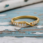 Gold ring with diamonds on a wood background