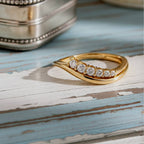 Gold ring with diamonds on a wood background