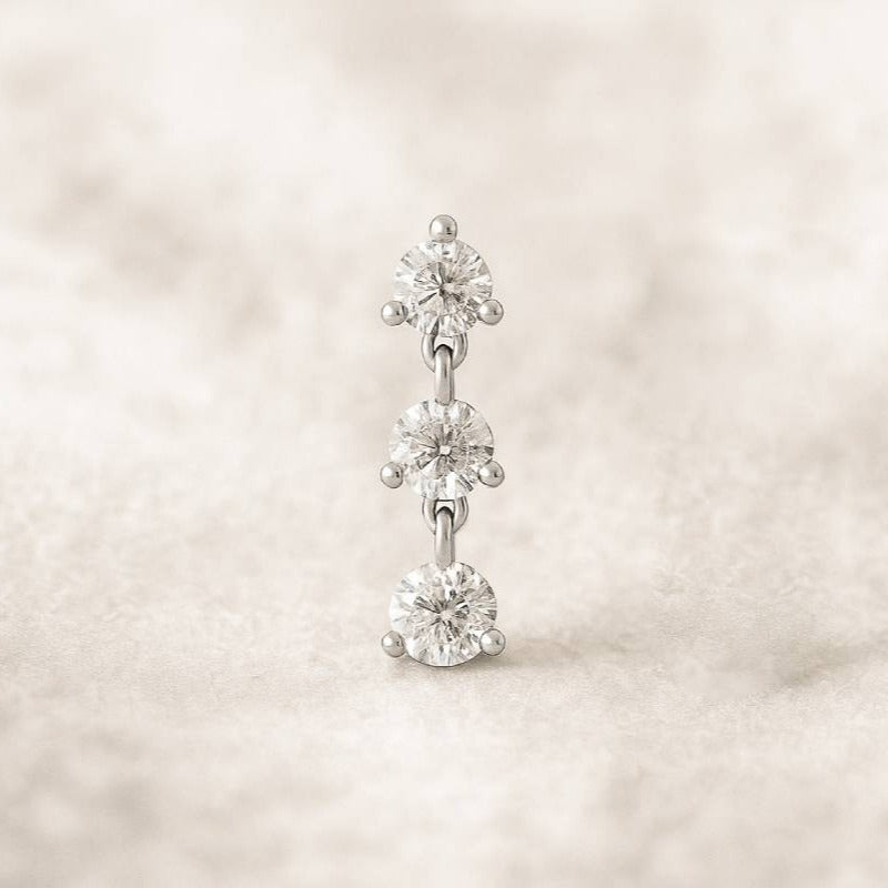 Diamond earring on a soft beige background