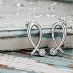 gold earrings with diamond accents on a wood background