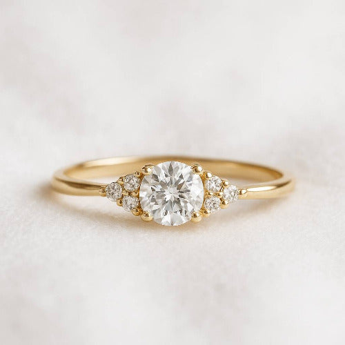 Gold ring with a large diamond and smaller diamonds on a light background