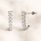 Pair of diamond earrings on a light beige background