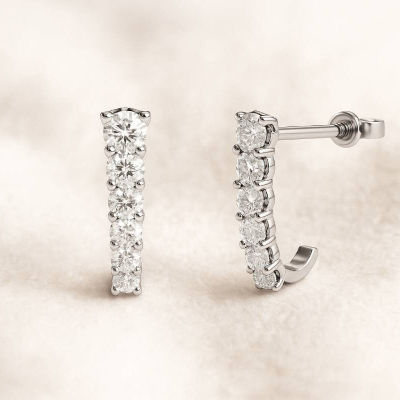 Pair of diamond earrings on a light beige background