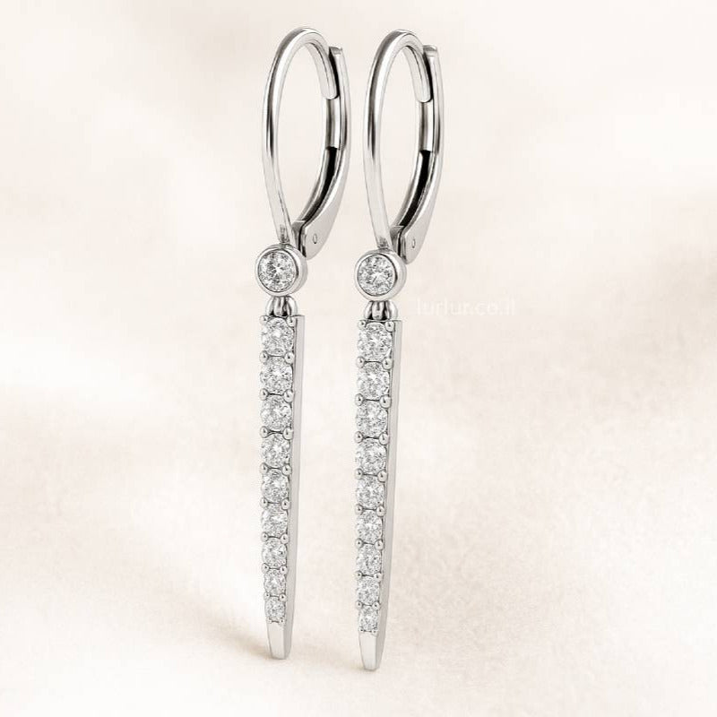 Pair of diamond earrings on a light pink background