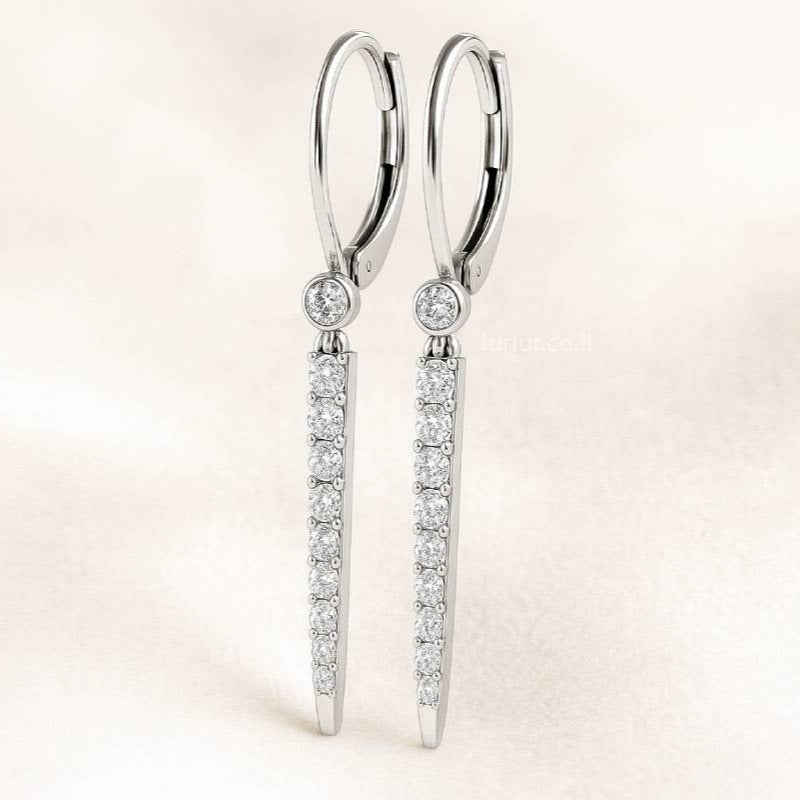 Pair of earrings with clear gemstones on a light pink background