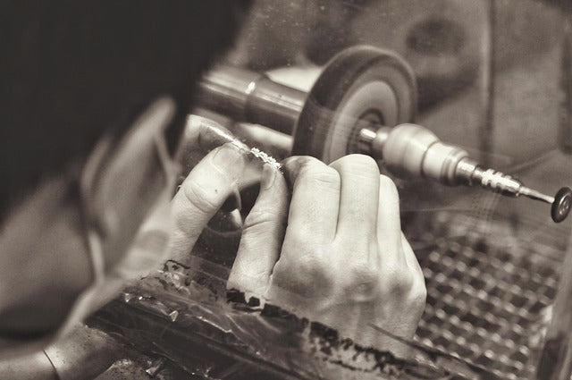 Close-up of hands working on a lathe with a focus on craftsmanship.